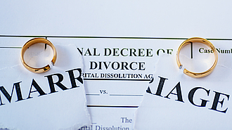 Trennungsfolge: Eheringe auf Scheidungsurkunde 